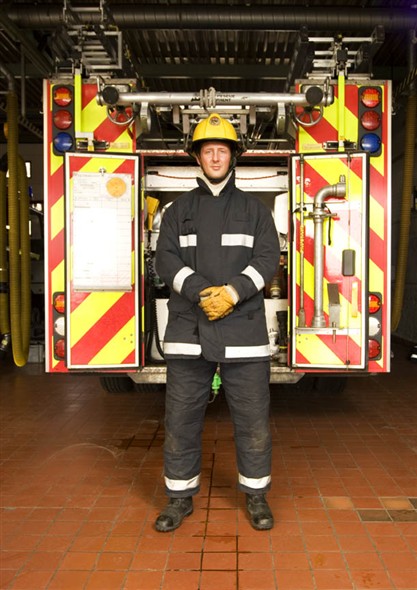 Photo:Portrait of fireman Aaron Tills infront of one of the fire engins